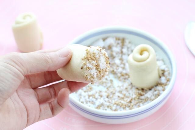 蜂蜜小面包,十克细砂糖中加入适量芝麻拌匀，将面胚切口的那面蘸上白糖芝麻。