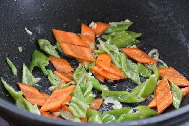 辣椒炒千张,接着放入尖椒和胡萝卜，翻炒一分钟左右断生。