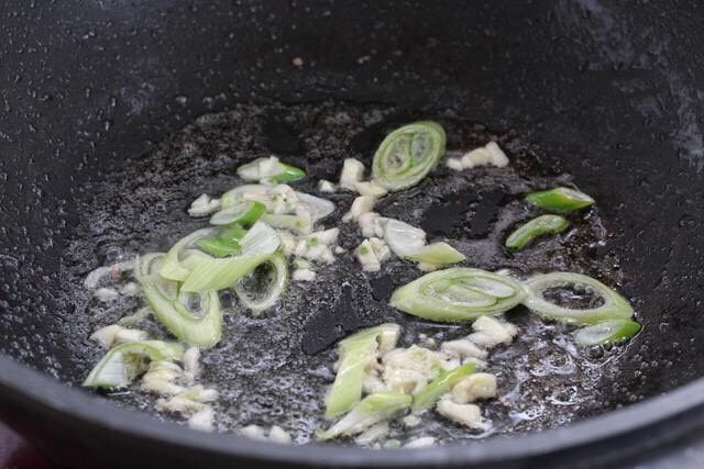 辣椒炒千张,就着锅中底油放入葱花和蒜末，小火炒出香味。