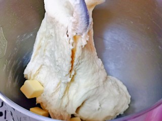 蜂蜜小面包,15分钟后，面团处于扩展阶段，加入室温软化的黄油，继续揉面，至揉出不容易破的手套膜即可。