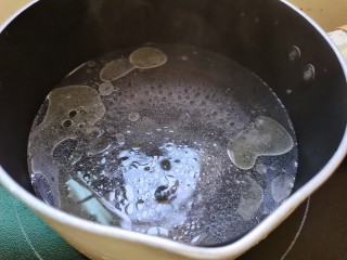 鸡蛋炒乌冬面,奶锅放入适量的水，加入几滴食用油