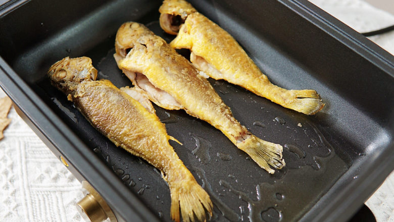 雪菜小黄鱼,锅中加少许油，黄花鱼煎至表面微黄，盛出。