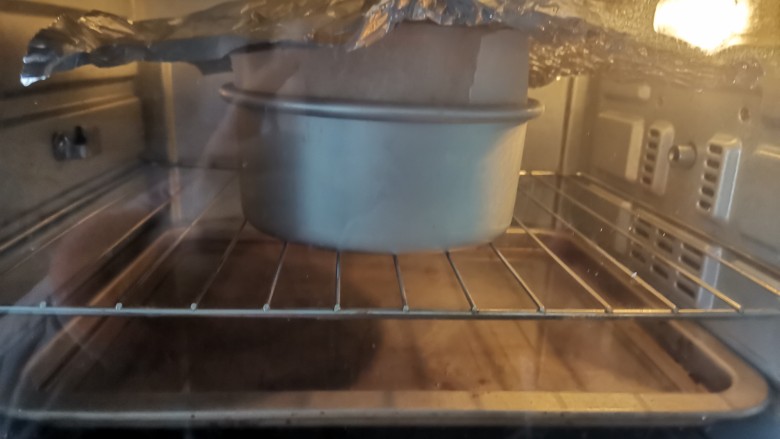 酸奶芝士蛋糕,送入预热好的烤箱，上下火160度烤60～70分钟，水浴法烘烤，蛋糕放中层烤网上，烤盘里加入3厘米的水放下层，蛋糕上色后盖锡纸