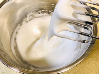 酸奶芝士蛋糕,继续搅打，分次加入剩余的糖霜，一直搅打至湿性状态，可以拉出长长的拉钩，就可以了，此时预热烤箱