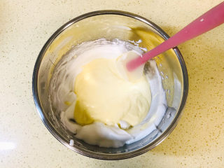 酸奶芝士蛋糕,将翻拌均匀的蛋黄糊倒入剩余的蛋白霜中
翻拌均匀