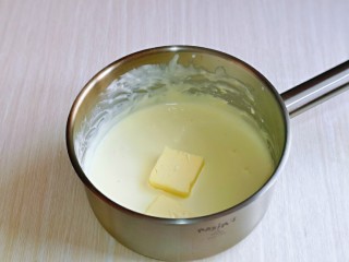 酸奶芝士蛋糕,融化至细腻，酸奶与奶酪完全融合，再加入黄油，继续隔水融化，搅拌至黄油与奶酪融合在一起。