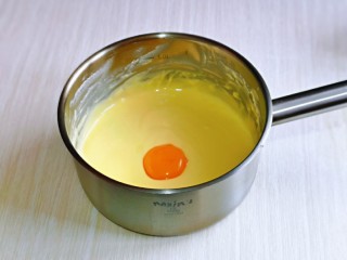 酸奶芝士蛋糕,将器具从热水中取出，先加入一个蛋黄，搅拌均匀后再加一个搅拌均匀，再加入第三搅拌均匀。(每次一定要搅拌均匀后再加入下一个蛋黄)
