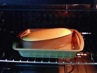 酸奶芝士蛋糕,将模具放入预热好有水的烤盘中，(水浴烤法）上下170度烤20分钟，20分钟后，蛋糕表面已经定型上色，这时将烤箱上下调到140度，烤40分钟，烤好后不要马上将模具取出，放在烤箱里焖30分钟。