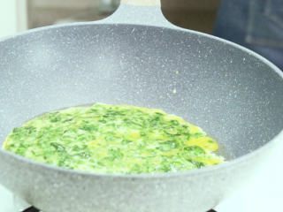 芹菜叶炒鸡蛋,把蛋液倒入锅中，稍后轻轻晃动锅子
