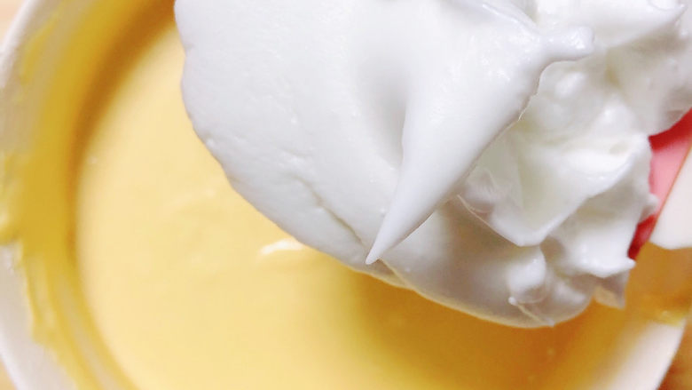 酸奶芝士蛋糕,把芝士糊从冰箱拿出来，经过冷藏的芝士糊会变得更浓稠一些。挖1/3蛋白到芝士糊里。