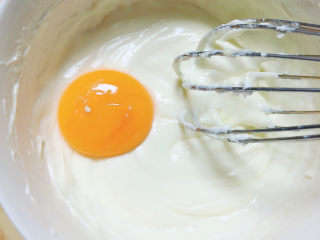 酸奶芝士蛋糕,蛋黄分次加入，搅打均匀。
