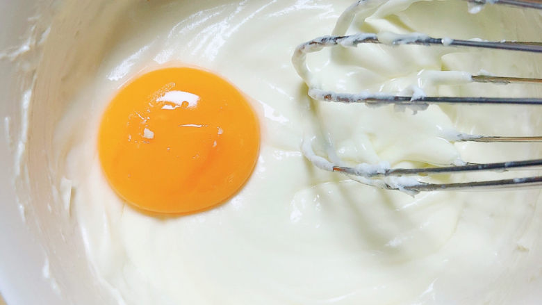 酸奶芝士蛋糕,蛋黄分次加入，搅打均匀。