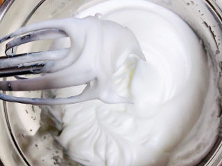 酸奶芝士蛋糕,打发好的蛋白，提起打蛋器以后，拉出一个弯弯的尖角。