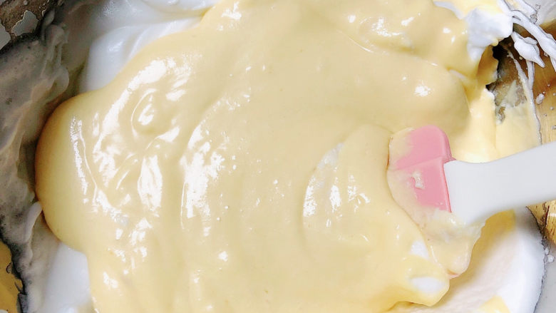 酸奶芝士蛋糕,用刮刀把蛋白和芝士糊拌匀。将蛋白和芝士糊拌匀以后，全部倒回蛋白碗里。