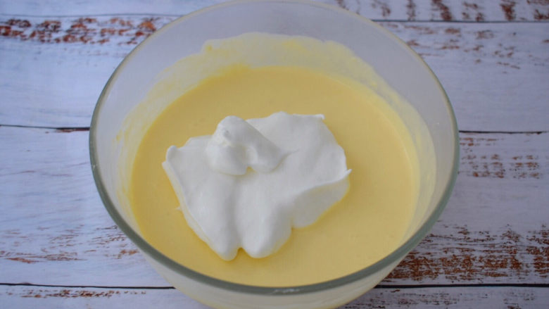 酸奶芝士蛋糕,把三分之一蛋白倒入奶酪糊中拌匀