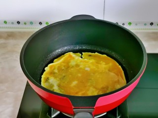 鸡蛋炒乌冬面,起油锅倒入蛋液，小火煎至凝固。