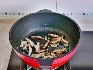 鸡蛋炒乌冬面,另起油锅加入蒜末炒香，再加入香菇煸炒。