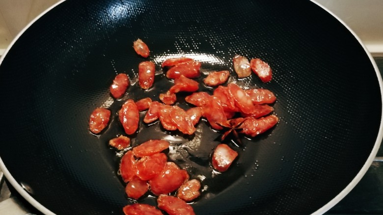 冬笋炒腊肉,放入腊肉肠翻炒至透明色。