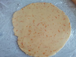 香橙🍊曲奇饼干, 把面团上下铺上保鲜膜，擀成3毫米厚的薄饼放入冰箱冷冻30分钟后，取出来用圆形模具压出形状