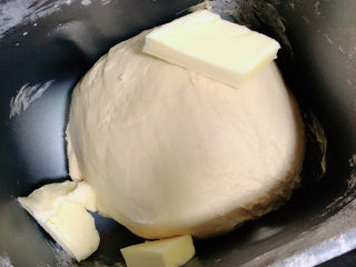 蜂蜜小面包,将面团揉至光滑，加入黄油，继续揉面。