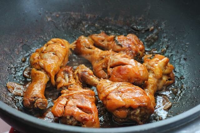 电饭锅焖鸡腿,到时间后把鸡腿倒回普通炒锅中，改大火翻炒收汁即可。