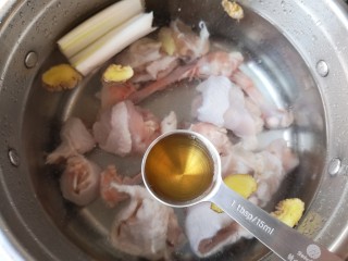 钵钵鸡,锅中凉水放入鸡腿肉和鸡骨，再下入葱白姜片和一勺料酒。