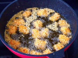 香酥鱿鱼米花,油温烧热至6成热时，放入鱿鱼块开始炸至。