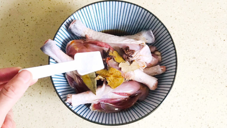 电饭锅焖鸡腿,撒入盐调味