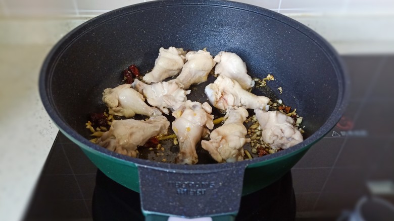 电饭锅焖鸡腿,放鸡腿翻炒至两面微黄。
