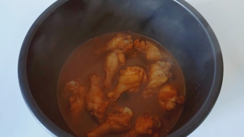 电饭锅焖鸡腿,加入适量的开水，放电饭煲炖煮15分钟左右。