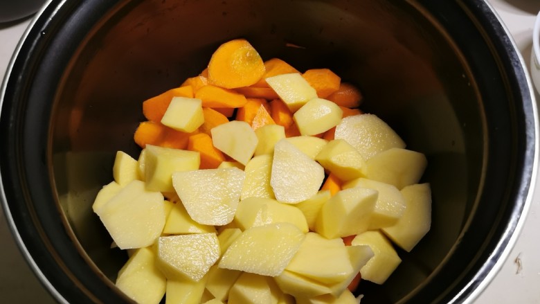 电饭锅焖鸡腿,取出电饭锅内胆，放入胡萝卜和土豆。