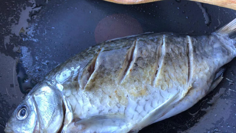 萝卜丝鲫鱼汤,轻轻在锅里滑动鲫鱼，让鱼受热均匀。