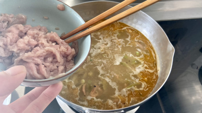 榨菜肉丝汤➕黄瓜榨菜肉丝汤,转中火，加入肉丝，用筷子搅散