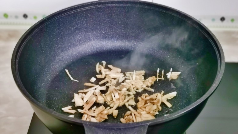 白玉菇豆腐汤,起油锅加入白玉菇丝煸炒。