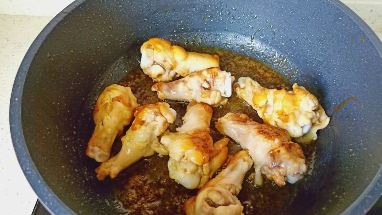 蒜香鸡腿,中小火慢慢熬至冰糖融化，加入鸡腿快速翻炒上色，加蒜泥炒香。