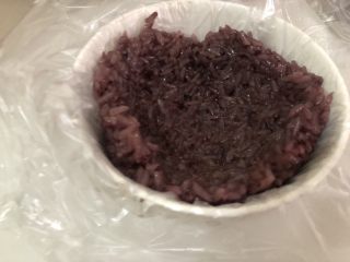 紫米饭团,把煮好的紫糯米饭装一部分到碗里 用勺子往四周擀开擀薄