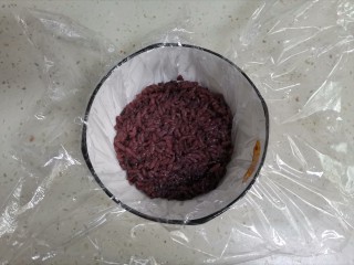 紫米饭团,取一个小碗，铺上保鲜膜，舀一勺紫米饭压实