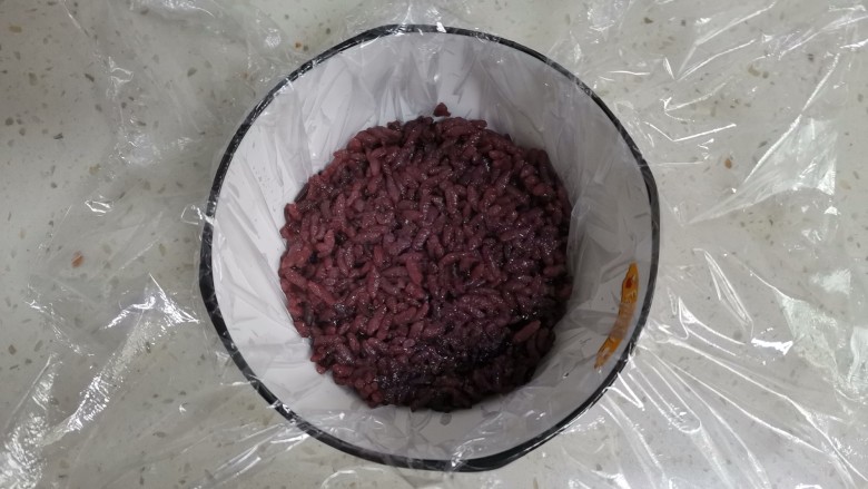 紫米饭团,取一个小碗，铺上保鲜膜，舀一勺紫米饭压实