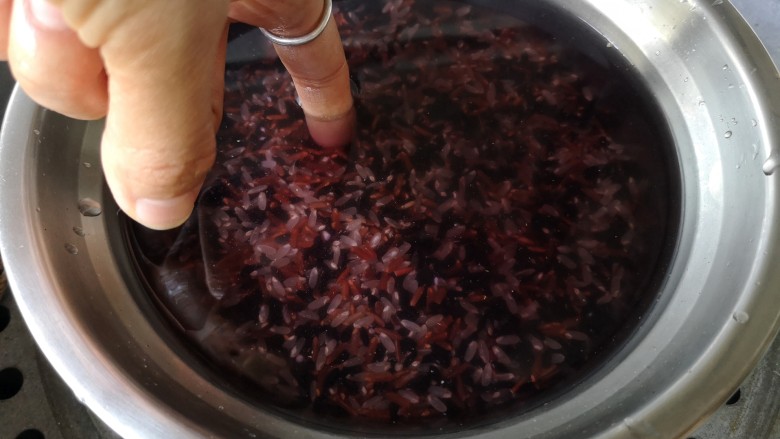 紫米饭团,<a style='color:red;display:inline-block;' href='/shicai/ 211581'>紫米</a>洗净，无需浸泡。像平时蒸米饭一样，加入米面一指节深度的水上锅隔水蒸40分钟。