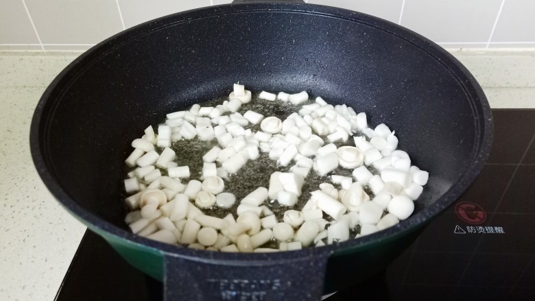 白玉菇豆腐汤,热锅热油放白玉菇翻炒。