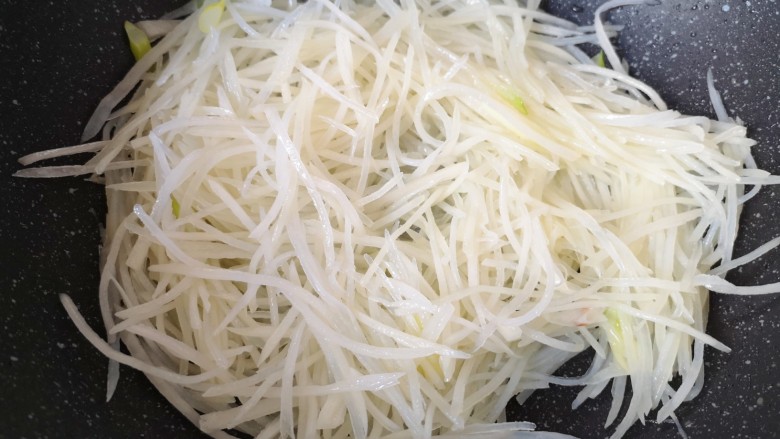 青椒炒土豆丝,翻炒至土豆丝微微变的透明。