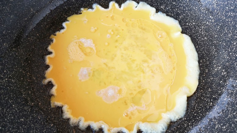 尖椒炒鸡蛋,炒锅内倒适量的食用油烧热，倒入蛋液。