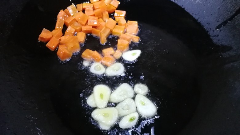 清炒黄豆芽,把胡萝卜推到一边，放入蒜片炒香。