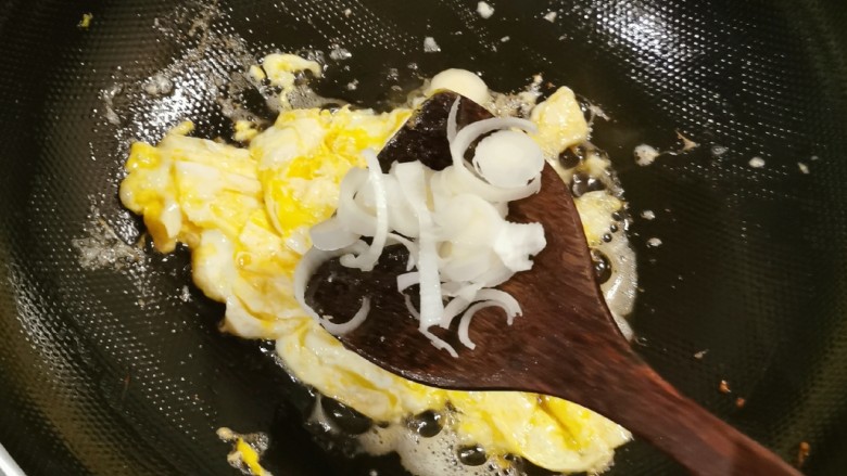 尖椒炒鸡蛋,倒入葱片去腥增香。