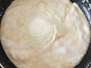 小圆饼牛扎饼干,倒入加入奶粉，快速搅拌均匀，使棉花糖与奶粉混合
