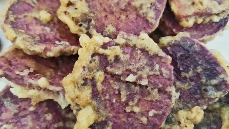 炸紫薯片,最后再放进烧至9分熟的热油中炸至表面呈金黄色，再捞出控油放盘中