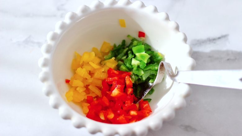 彩椒蒜香海虹,把切碎的青、红、黄椒放入碗里。