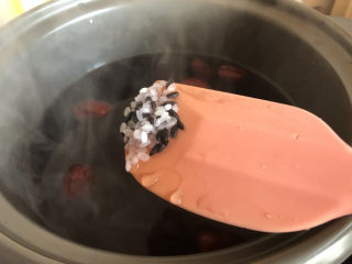 红枣黑米粥,待水开后放入洗干净的大米跟黑米，用勺子搅拌几下。