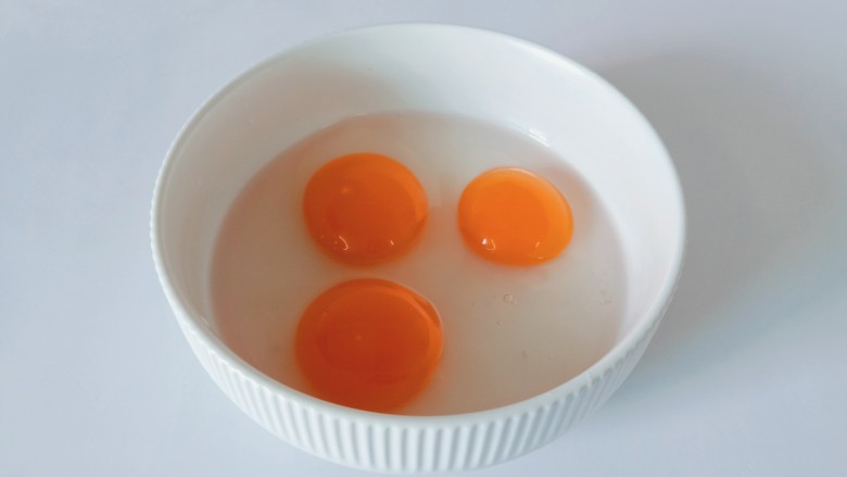 尖椒炒鸡蛋,把三个鸡蛋放到碗里。
