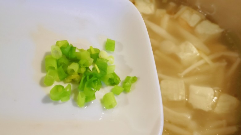 白玉菇豆腐汤,放入香葱绿，淋入芝麻油关火出锅。